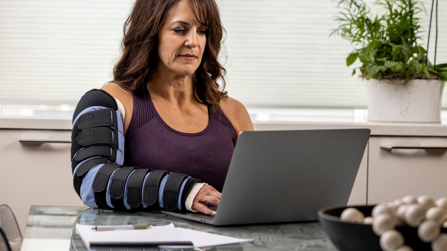 woman working on computer with arm wrap